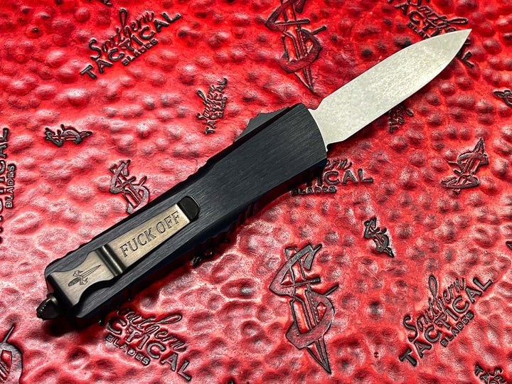 Marfione Custom Knives / Borka Blades Collaboration Combat Troodon, Chisel Grind, Borka Signature Rocker Grind, Black Hefted Aluminum Alloy Chassis, Carbon Fiber Button, DLC Two-Tone Hardware. DLC “Fuck Off” (Family Only) Pocket Clip. 1 of 3 Made.